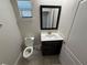 Powder room with modern vanity, toilet, tile flooring, and a framed mirror above the sink at 220 Brookes Pl, Haines City, FL 33844