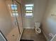 Bright bathroom with glass shower, window, and toilet, featuring neutral tile flooring at 220 Brookes Pl, Haines City, FL 33844