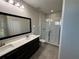 Bathroom featuring double sink vanity, a framed mirror, and glass-enclosed shower at 220 Brookes Pl, Haines City, FL 33844