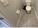 A compact toilet area featuring neutral tile flooring and essential fixtures at 220 Brookes Pl, Haines City, FL 33844