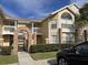 Inviting yellow condo building with brick archway, well-maintained landscaping, and multiple levels of living at 2494 Sweetwater Club Cir # 55, Kissimmee, FL 34746