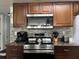 Kitchen with stainless steel appliances, mosaic tile backsplash, and dark wood cabinetry at 2494 Sweetwater Club Cir # 55, Kissimmee, FL 34746