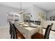 Formal dining room featuring a long table set for eight, a modern light fixture, and bright natural light at 2663 Sand Hill Point Cir, Davenport, FL 33837