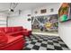 This entertainment room has a red leather sectional sofa, and a checkerboard floor with a Mario Kart mural at 2663 Sand Hill Point Cir, Davenport, FL 33837