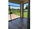 Screened patio with dark tile and view of the backyard with green grass and white fence at 2885 Running Brook Cir, Kissimmee, FL 34744