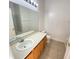 Simple bathroom with a tub-shower combo, toilet, sink with cabinet, and large mirror at 296 Sand Ridge Dr, Davenport, FL 33896