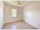 A well-lit bedroom with tiled floor, window, and ceiling fan at 296 Sand Ridge Dr, Davenport, FL 33896