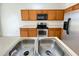 A stainless double sink features in this kitchen with appliances and ample wooden cabinet space at 296 Sand Ridge Dr, Davenport, FL 33896