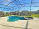 View of the pool and spa surrounded by a screened-in patio enclosure at 296 Sand Ridge Dr, Davenport, FL 33896