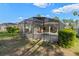 Backyard with lush landscaping, mature trees, screened pool, and outdoor entertaining area at 311 N Hampton Dr, Davenport, FL 33897