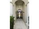 Inviting front entryway featuring decorative columns and a charming, secure front door at 311 N Hampton Dr, Davenport, FL 33897