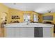 Kitchen featuring an island with sink, white cabinets, and open layout to the breakfast nook and living area at 311 N Hampton Dr, Davenport, FL 33897