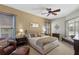 Comfortable main bedroom with a fan, neutral walls, a large bed, and views to the lanai and pool at 311 N Hampton Dr, Davenport, FL 33897