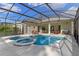 Outdoor pool with attached spa is surrounded by a large screened enclosure, ideal for backyard enjoyment at 311 N Hampton Dr, Davenport, FL 33897