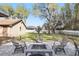 Large backyard with a stone fire pit and seating under mature trees at 3165 Maple Run, Kissimmee, FL 34744