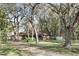 Single-story home with stone accents, surrounded by mature trees and a large yard at 3165 Maple Run, Kissimmee, FL 34744