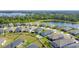 Stunning aerial view of the neighborhood showcasing homes with a community pool, and a serene lake at 3240 Songbird Cir, Harmony, FL 34773