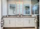 Bathroom featuring double vanity sinks with white cabinets and mirrors at 3240 Songbird Cir, Harmony, FL 34773