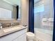 Bathroom featuring a vanity sink with a white-framed mirror and a bathtub shower with white tiles at 3240 Songbird Cir, Harmony, FL 34773