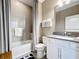 Well-lit bathroom featuring tiled walls, a shower with glass door, and a white vanity with grey countertop at 3240 Songbird Cir, Harmony, FL 34773