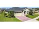 Beautiful single-story home showcasing manicured landscaping and a brick driveway leading to a two-car garage at 3240 Songbird Cir, Harmony, FL 34773