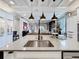 Modern kitchen island with stainless steel sink, black faucet, and pendant lighting at 3240 Songbird Cir, Harmony, FL 34773
