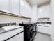 Modern laundry room featuring sleek cabinetry, a black washer and dryer set, and a convenient utility sink at 3240 Songbird Cir, Harmony, FL 34773