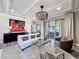 Bright living room with modern chandelier, neutral decor, and sliding glass doors to outdoor living space at 3240 Songbird Cir, Harmony, FL 34773
