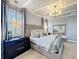 Staged main bedroom showcasing pendant lights, a gray upholstered king bed, and windows with blinds at 3240 Songbird Cir, Harmony, FL 34773