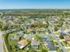 Aerial view showcases the neighborhood with mature trees, water feature, and homes at 3303 Ann Arbor Ct, St Cloud, FL 34772