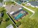 Aerial view of the backyard with a screened-in pool, white fencing, well-manicured lawn and patio furniture at 3303 Ann Arbor Ct, St Cloud, FL 34772