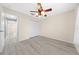 Clean, empty bedroom with gray floors, a ceiling fan, and an adjacent tiled bathroom at 3303 Ann Arbor Ct, St Cloud, FL 34772