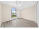 A vacant bedroom with wood floors, neutral paint, a ceiling fan, and a window offering natural light at 3303 Ann Arbor Ct, St Cloud, FL 34772