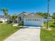 Well-maintained home with a lush lawn, a two-car garage, and a driveway surrounded by mature trees at 3303 Ann Arbor Ct, St Cloud, FL 34772