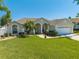 Beautiful single-story home with a well-manicured lawn, palm trees and a two car garage at 3303 Ann Arbor Ct, St Cloud, FL 34772