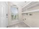 Bright laundry room with window, tile floor, and modern shelving units at 3303 Ann Arbor Ct, St Cloud, FL 34772