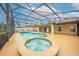 Inviting screened-in pool area with a jacuzzi, perfect for relaxing and enjoying the outdoors at 3303 Ann Arbor Ct, St Cloud, FL 34772