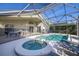 Screened-in pool area with a spa, pool, and outdoor seating, ideal for entertaining at 366 Highgate Park Blvd, Davenport, FL 33897