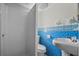 Bathroom with blue ceramic tile, shower, and white fixtures at 425 S 12Th St, Lake Wales, FL 33853