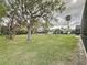 Spacious backyard with mature trees, lush lawn, and screened pool at 4602 Cumbrian Lakes Dr, Kissimmee, FL 34746