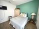 Comfortable bedroom featuring a teal accent wall, wood-look floors, and a glass side table at 4602 Cumbrian Lakes Dr, Kissimmee, FL 34746