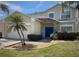 Charming two-story home featuring a stone-accented entrance, blue double doors, and lush landscaping at 4602 Cumbrian Lakes Dr, Kissimmee, FL 34746