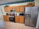 Bright kitchen featuring wooden cabinetry, modern appliances, and neutral tile flooring at 4602 Cumbrian Lakes Dr, Kissimmee, FL 34746