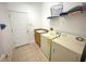 Functional laundry room with washer, dryer, utility sink, and tile floors at 4602 Cumbrian Lakes Dr, Kissimmee, FL 34746