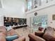 Bright living room with high ceilings, shelving, and sliding glass doors to the pool area at 4602 Cumbrian Lakes Dr, Kissimmee, FL 34746