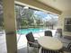Covered patio features dining set and comfortable lounge seating by the pool at 4602 Cumbrian Lakes Dr, Kissimmee, FL 34746