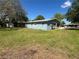 A backyard view of the home featuring carport, shed, and grass at 4625 Weston Rd, Bartow, FL 33830