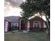 Charming home with a well-maintained front yard, mature tree, and classic architectural details at 516 Brentford Ct, Kissimmee, FL 34758