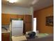 Functional kitchen with white appliances, wood cabinets, and breakfast bar at 516 Brentford Ct, Kissimmee, FL 34758