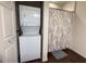 Functional bathroom with a stacked washer/dryer and a shower/tub with patterned curtain at 5364 Diplomat Ct # 106, Kissimmee, FL 34746